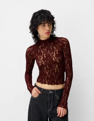 Camiseta rubia de encaje con cuello alto y manga larga